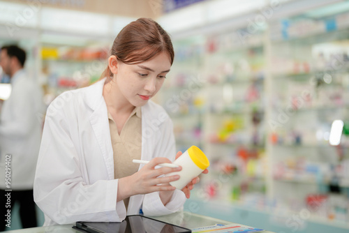 A woman pharmacist inspects a medication bottle, ensuring accuracy in prescription filling. pharmacists in patient safety and careful medication handling. daily operations in a modern pharmacy. photo