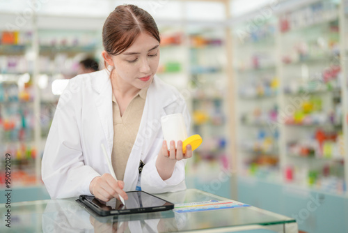 A woman pharmacist inspects a medication bottle, ensuring accuracy in prescription filling. pharmacists in patient safety and careful medication handling. daily operations in a modern pharmacy. photo