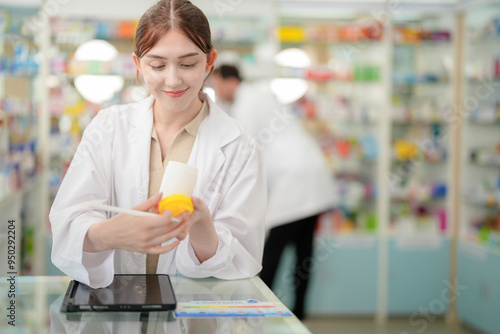 A woman pharmacist inspects a medication bottle, ensuring accuracy in prescription filling. pharmacists in patient safety and careful medication handling. daily operations in a modern pharmacy. photo