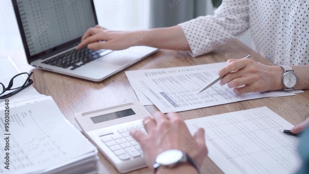 Professional female bookkeeper or auditor are working on business finances with a colleague, using calculator and laptop. Finance audit and taxes Professional female bookkeeper or auditor are working on business finances with a colleague, using calculator and laptop. Finance audit and taxes