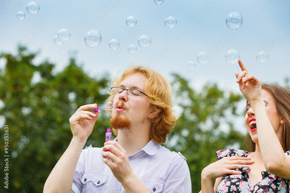 Couple blowing soap bubbles, having fun Couple blowing soap bubbles, having fun