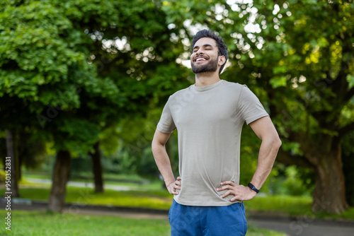 Фотография Joyful sportsman relaxing in park after invigorating workout outdoors on sunny d
