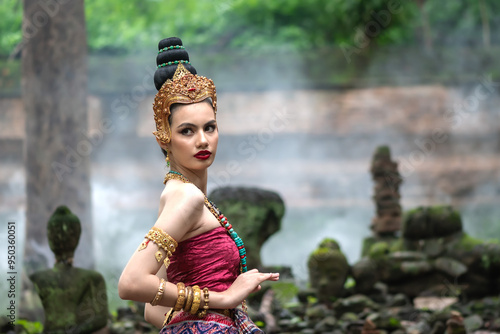 Pretty woman in apsara dvaravati costume standing in ancient temple photo