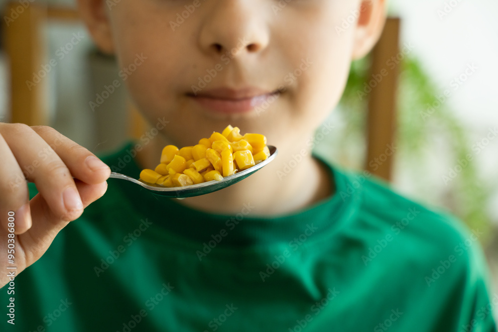 Boy eats marinated corn. Focus on the food and face on background Boy eats marinated corn. Focus on the food and face on background