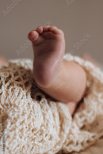 Sweet little foot of newborn baby on beige background, baby care and parenthood concept