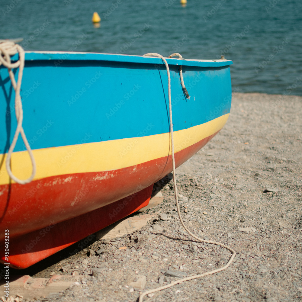 Small colorful wooden boat on a beach in the Mediterranean Sea. Small colorful wooden boat on a beach in the Mediterranean Sea.