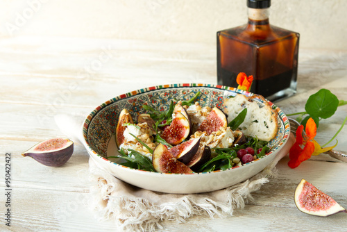 bowl of salad with arugula, cheese and figs on a light table
