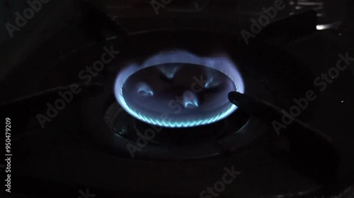 Blue flame burning on a gas stovetop burner.