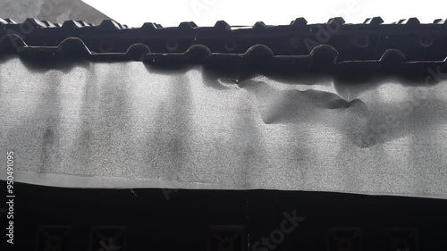 Close-up of a damaged roof with water dripping.