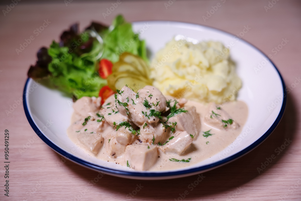 Chicken in cream sauce served with mashed potatoes and salad. Chicken in cream sauce served with mashed potatoes and salad.