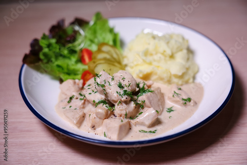 Chicken in cream sauce served with mashed potatoes and salad.