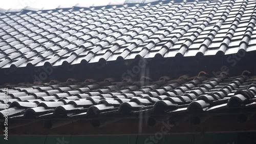 Close-up of a tiled roof with raindrops.