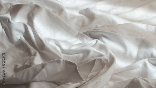 Photograph of the detail of discarded sheets on a luxury hotel bed.