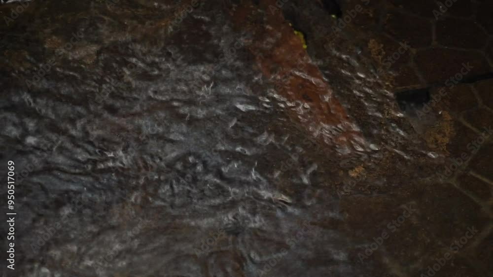 Close-up of rippling water flowing over textured stone. Close-up of rippling water flowing over textured stone.
