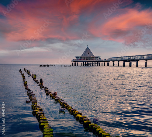 Mettal boat ramp and ruins of old wooden pier on empty beach. Splendid summer sunset on popular tourist attraction - Heringsdorf Pier with a lots of Shopping mail, Germany, Europe. Travel the world.. photo