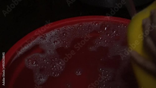 Red basin filled with soapy water and bubbles.