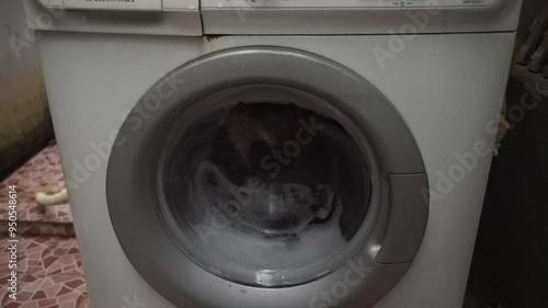 White washing machine with clothes inside.