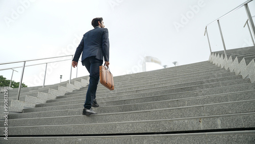 Billede på lærred Top view of smart business man walking up stairs with bag in the hand