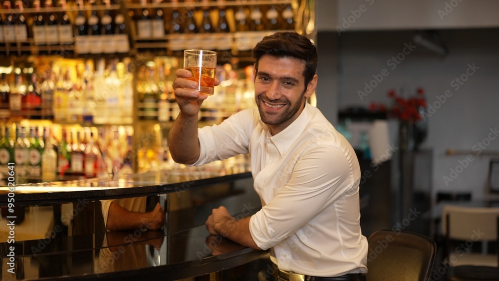 Profile of smiling smart man in white shirt drinking cocktail in Old fashioned looking at camera of special party beverage vibrant on Friday night meeting at luxurious counter bar nightclub. Vinosity. Profile of smiling smart man in white shirt drinking cocktail in Old fashioned looking at camera of special party beverage vibrant on Friday night meeting at luxurious counter bar nightclub. Vinosity.