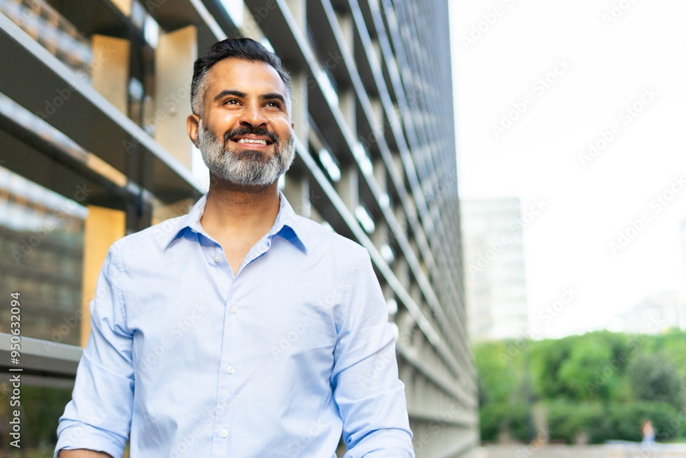 Smiling Indian businessman looking away in the city Smiling Indian businessman looking away in the city