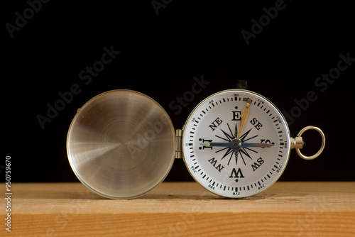 open Compass on a wooden table against a black background