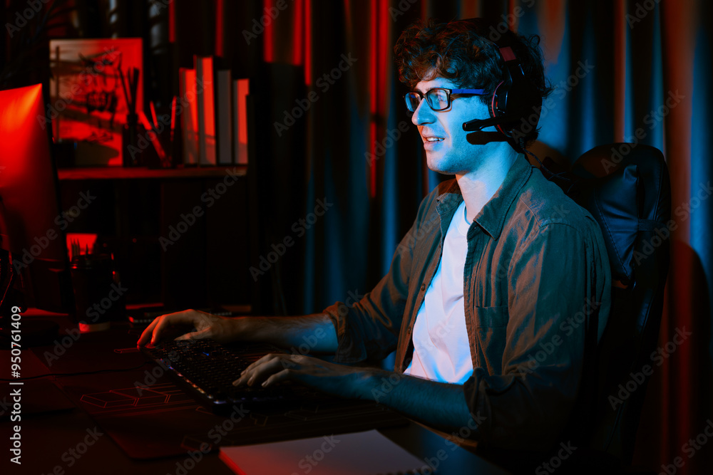 Smiling young gaming streamer team playing with joystick on Esport online on pc fighting game, try to win competitors on strategy planning for next harder at red neon lighting modern room. Gusher. Smiling young gaming streamer team playing with joystick on Esport online on pc fighting game, try to win competitors on strategy planning for next harder at red neon lighting modern room. Gusher.
