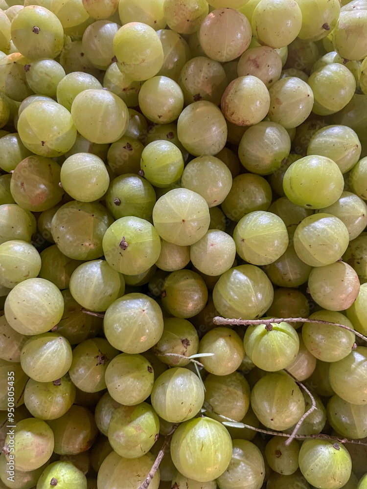photo of pile of indian gooseberries (Phyllanthus emblica) in crate on supermarket.this photo was taken from Bangladesh.