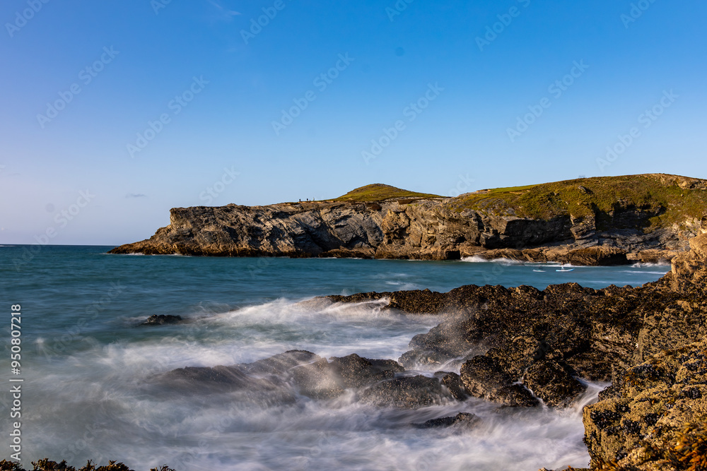Waves crashing on rocks at newquay beach headland in cornwall, england