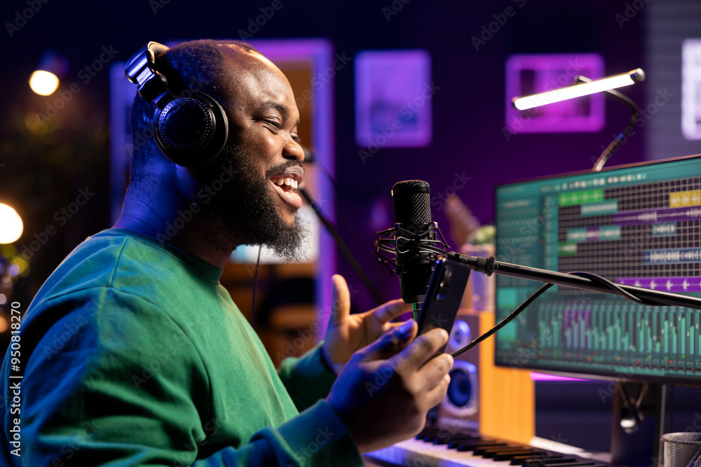 Young composer recording his new soundtrack on home studio microphone, performing his song before editing and adding sound effects. Confident producer creating music for an album. Young composer recording his new soundtrack on home studio microphone, performing his song before editing and adding sound effects. Confident producer creating music for an album.