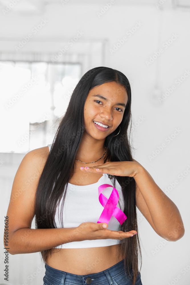 Brunette Latina woman proudly showing her breast cancer, wellness and pride ribbon Brunette Latina woman proudly showing her breast cancer, wellness and pride ribbon