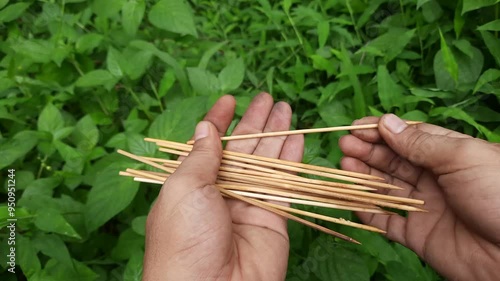 4k footage of someone breaking satay sticks. bamboo stick photo