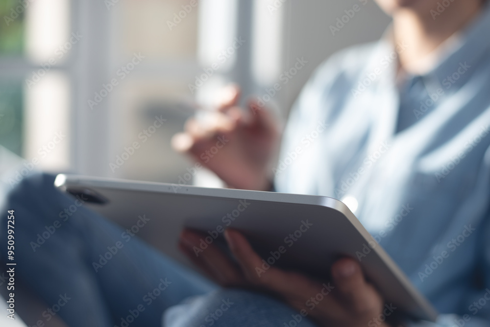 Close up, woman in casual wear sitting on the floor using digital tablet, online working from home office. remote work.Female student studying online, internet networking Close up, woman in casual wear sitting on the floor using digital tablet, online working from home office. remote work.Female student studying online, internet networking