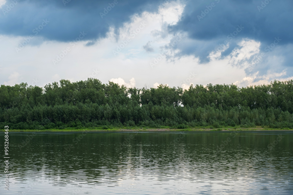 Serene landscape of forest and calm lake, with reflections of trees on the water. Serene landscape of forest and calm lake, with reflections of trees on the water.