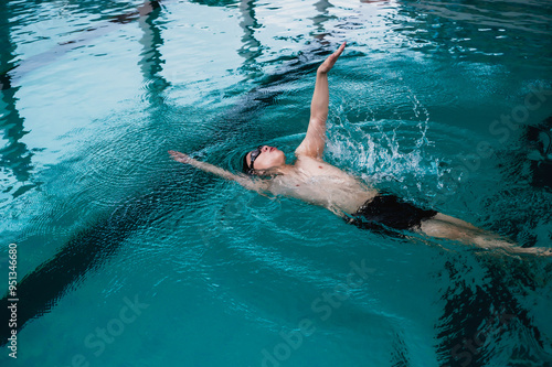 Quadro em tela Professional Asian male swimmer swimming freestyle in pool