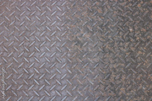 Close-up of a rusty metal surface with a diamond pattern.