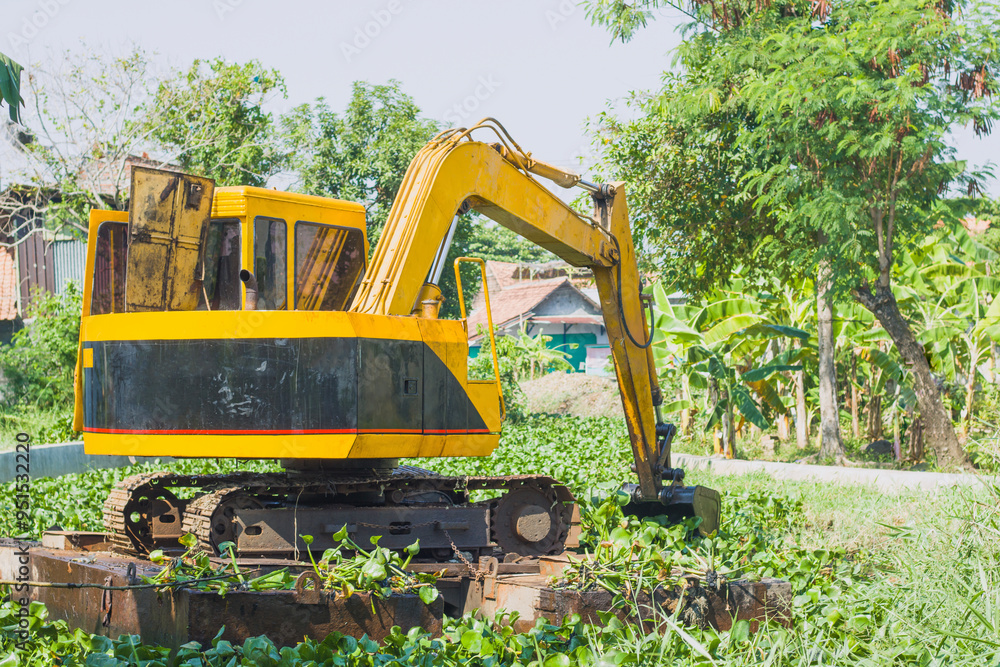 Normalizing rivers filled with water hyacinth and wild grass using heavy equipment, floating excavators, caterpillars on pontoons Normalizing rivers filled with water hyacinth and wild grass using heavy equipment, floating excavators, caterpillars on pontoons