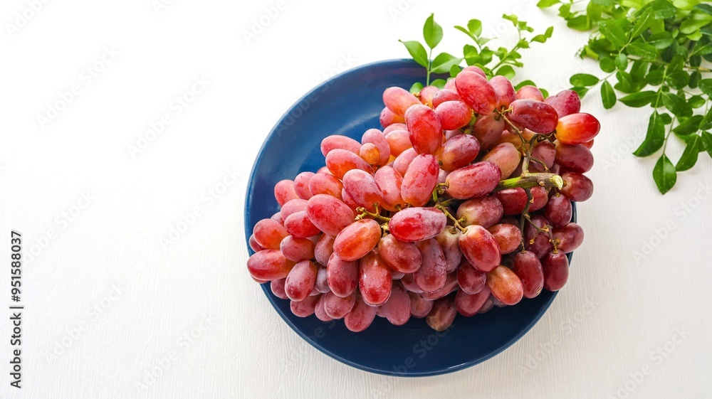 bunch of red seedless grapes in ceramic blue plate , on white background, fresh red grapes fruit bunch of red seedless grapes in ceramic blue plate , on white background, fresh red grapes fruit