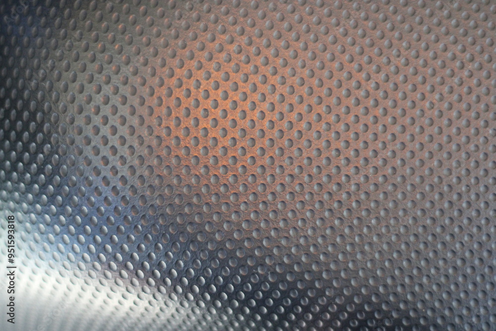 Close-up of a textured surface with small, round indentations. Close-up of a textured surface with small, round indentations.