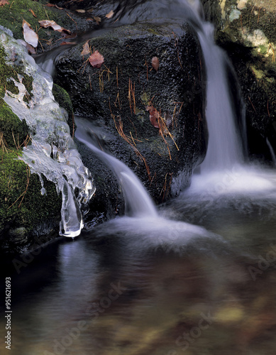 Yangpyeong-gun, Gyeonggi-do, South Korea - February 1, 2006: Winter view of icicle on the rock with green moss and a small waterfall at Yongmunsan Valley photo