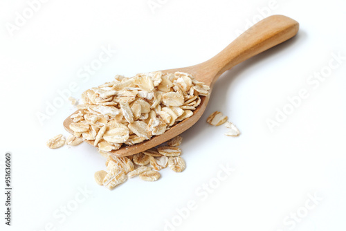 Oat flakes on wooden spoon close up on white background.