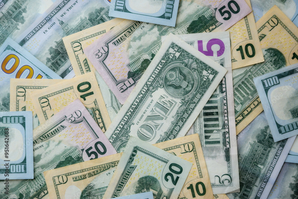 Big amount of US dollar bills in different nominations on table. Many dollar banknotes under natural light Big amount of US dollar bills in different nominations on table. Many dollar banknotes under natural light