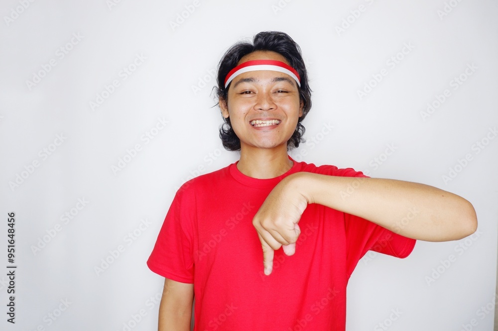 Portrait of an Indonesian man with long hair with a headband and red shirt celebrating Indonesian Independence Day with high nationalism on an isolated white background Portrait of an Indonesian man with long hair with a headband and red shirt celebrating Indonesian Independence Day with high nationalism on an isolated white background