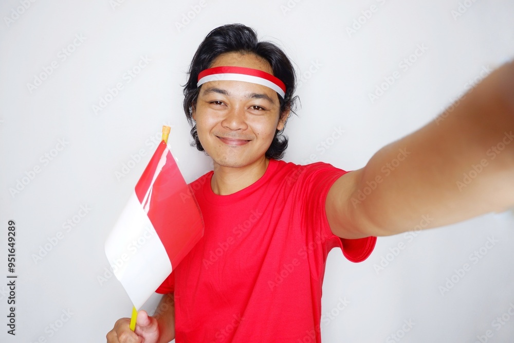 Portrait of an Indonesian man with long hair with a headband and red shirt celebrating Indonesian Independence Day with high nationalism on an isolated white background Portrait of an Indonesian man with long hair with a headband and red shirt celebrating Indonesian Independence Day with high nationalism on an isolated white background