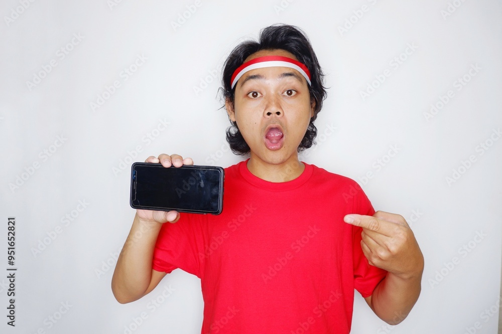Portrait of an Indonesian man with long hair with a headband and red shirt celebrating Indonesian Independence Day with high nationalism on an isolated white background Portrait of an Indonesian man with long hair with a headband and red shirt celebrating Indonesian Independence Day with high nationalism on an isolated white background