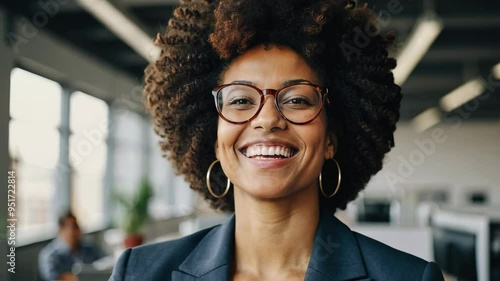Confident black woman with afro hair smiling in a startup office