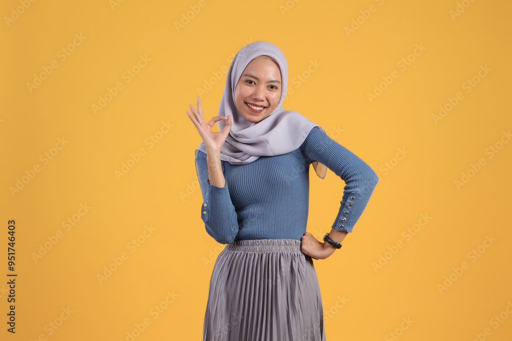 happy asian indonesian muslim woman giving ok finger gesture on isolated yellow background happy asian indonesian muslim woman giving ok finger gesture on isolated yellow background