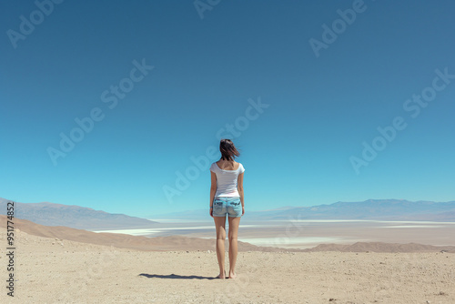 Back View of Unrecognizable Woman on Sandy Terrain in Argentina. Concept of Solitude and Adventure Under a Clear Blue Sky. Generative AI