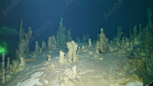 A deep blue ocean with a rocky bottom. A man is swimming in the water. The water is calm and clear photo