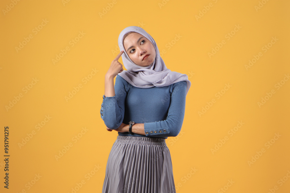 pensive asian indonesian muslim woman with thinking gesture on isolated yellow background pensive asian indonesian muslim woman with thinking gesture on isolated yellow background