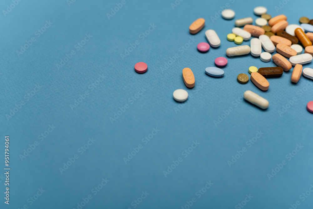 Multi-colored vitamin pills on a blue background Multi-colored vitamin pills on a blue background